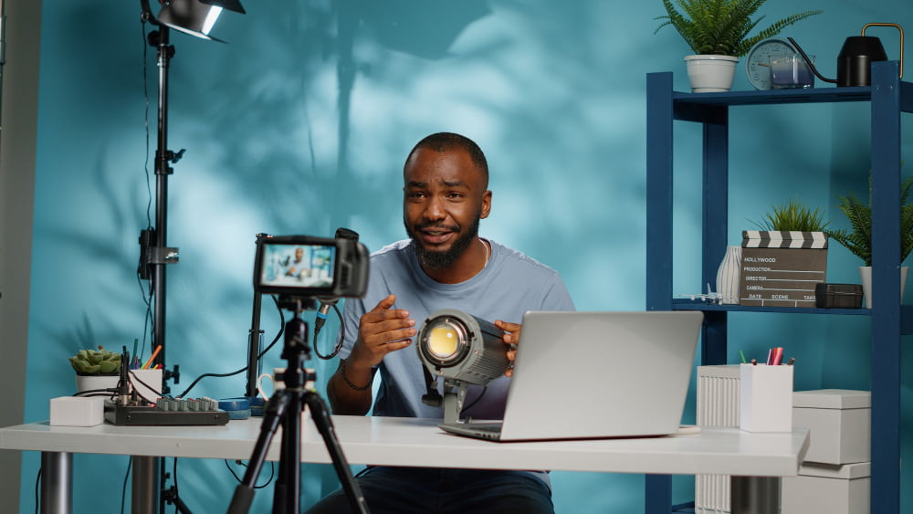 Como se tornar um profissional de produção de vídeo? 2 african american blogger reviewing studio light camera